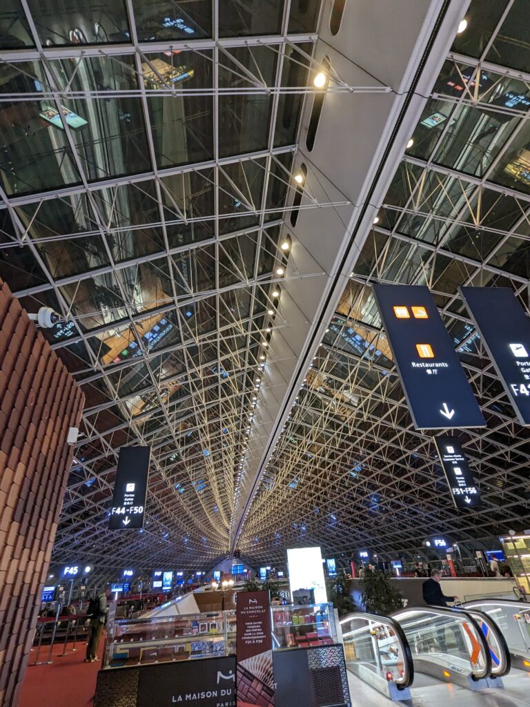 view of sculptural criss-crossed beams on a vaulted airport ceiling